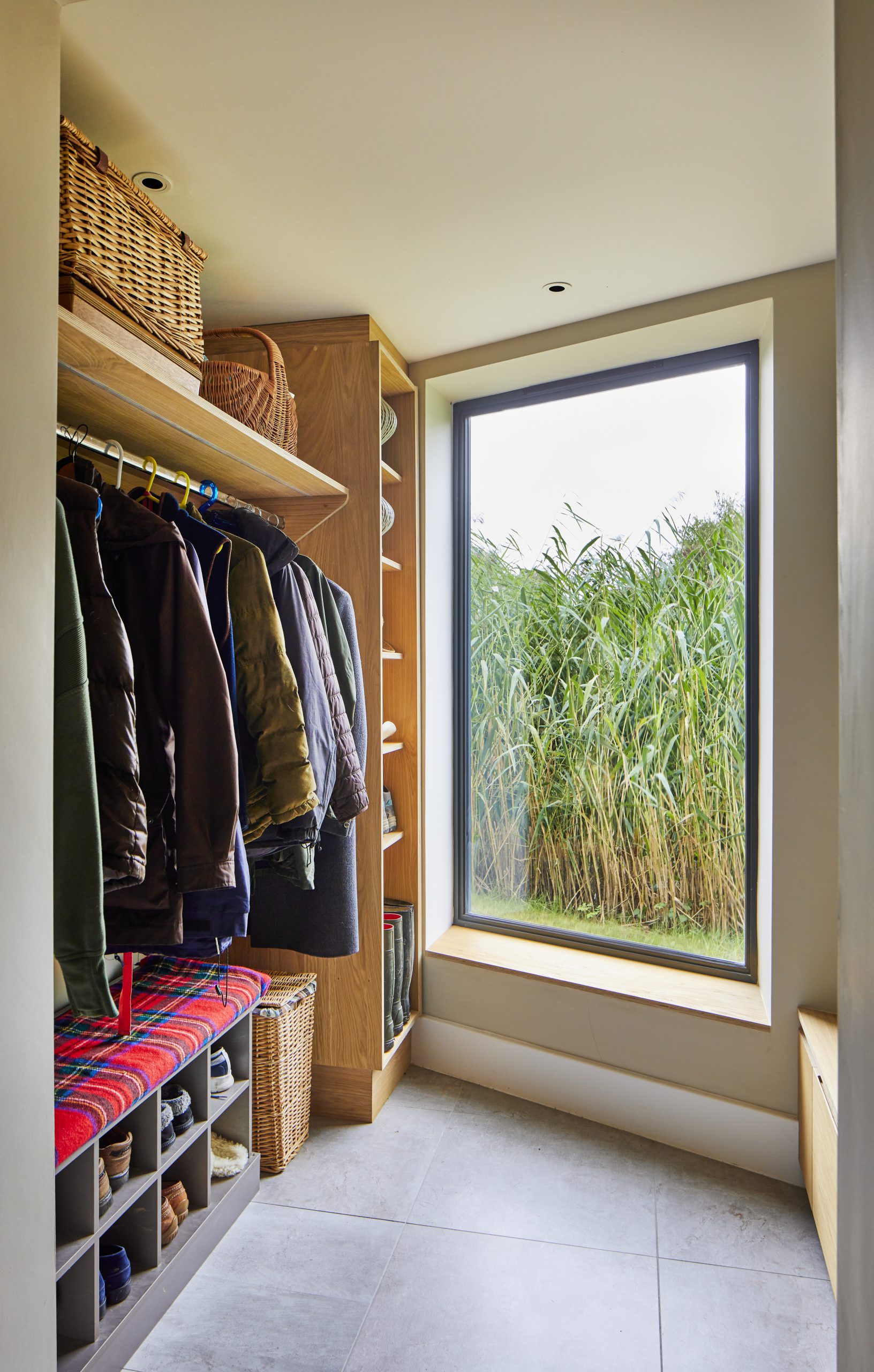 large picture window with view of the greenery around the lake. storage area for coats, hats and wellies