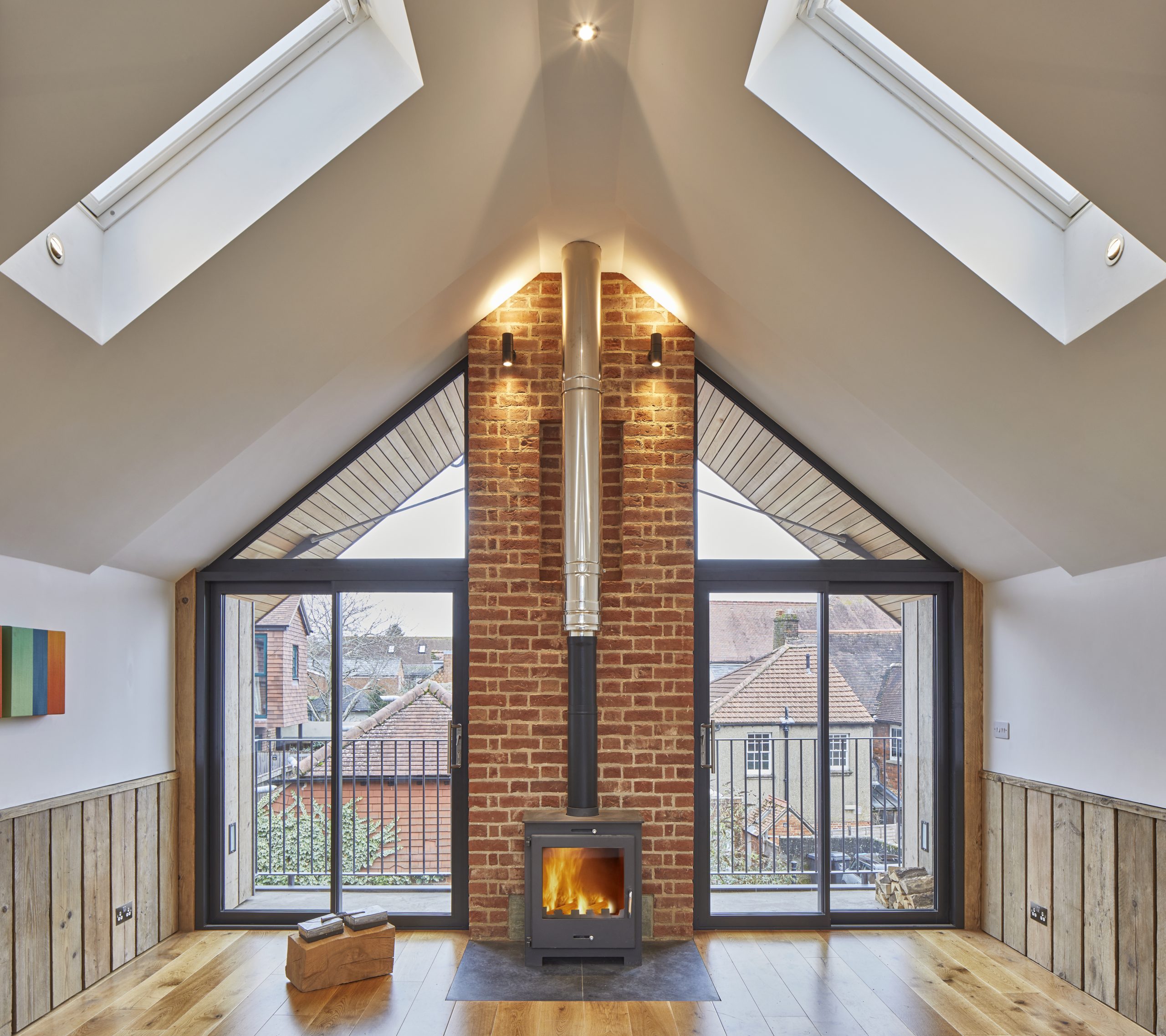 A modern loft building with glazing. A woodburning stove and wood flooring