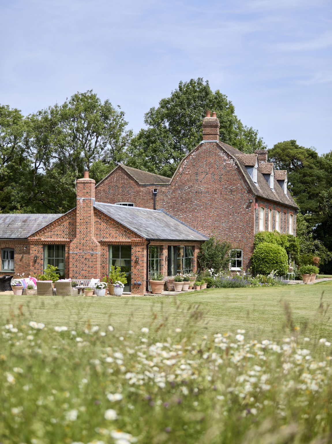 milton Architects — brick farmhouse in a wildflower meadow